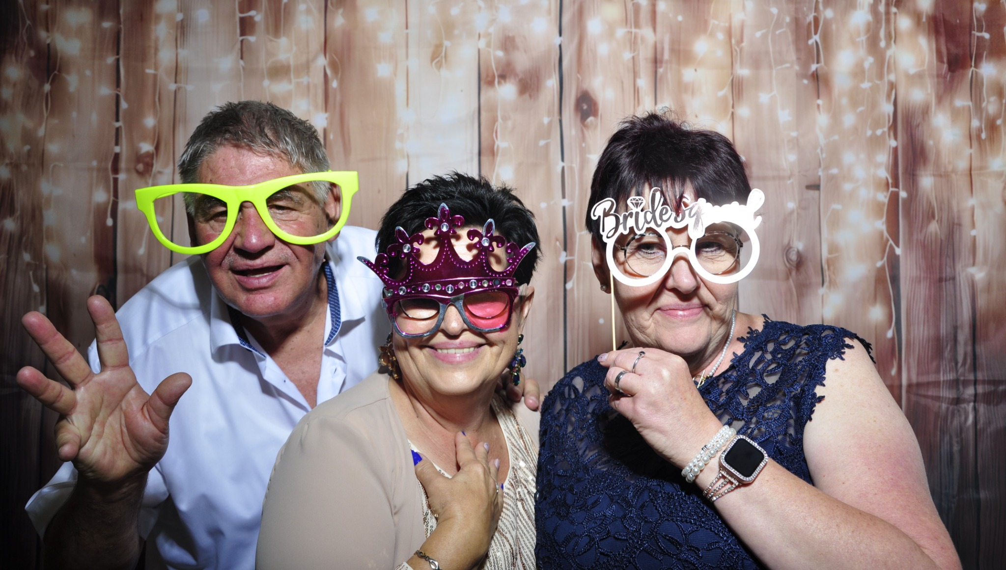 Lachende Gäste mit Requisiten vor der Fotobox